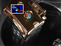 Abbildung: Herzstück des Experiments: Ein einzelnes Atom wird im schmalen Spaltzwischen zwei hochreflektierenden Spiegeln (hellblau) gefangen. Werden nuneinzelne Photonen vom Resonator reflektiert, wird dabei eine quantenlogischeRechenoperation zwischen dem Atom und den Photonen durchgeführt.