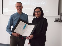 Immanuel Bloch presents Jelena Vučković with the MPQ Distinguished Scholar certificate.