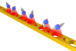 Artistic view of the atoms that work as qubits close to a “topological waveguide”.