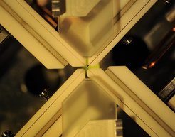 Crossed fiber cavity (center), fiber holders, shear piezoelectric elements and MOT mirrors