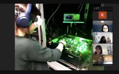 Sarah Hirthe shows the girls one of the experiments that she and her colleagues work on in their lab. She has to wear protective goggles to protect herself from the invasive light of the active laser.