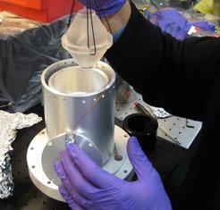 Figure 2: The mid-plane mounted high finesse cavity used for laser stabilization is lowered into its vacuum chamber.