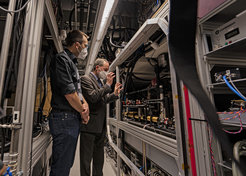 Sebastian Blatt, Forschungsleiter am MPQ und im Munich Quantum Valley (MQV), zeigt Minister Aiwanger einen der Quantensimulatoren am MPQ, aus dessen Technologie die WissenschaftlerInnen einen Quantencomputer basierend auf Neutralatomen bauen werden.