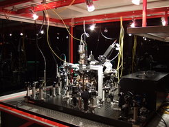 Experimenteller Aufbau mit Vakuumkammer auf einem optischen Tisch.