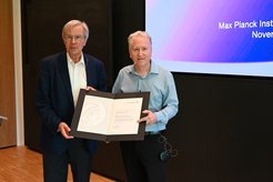 Theodor Hänsch verleiht Kerry Vahala im Rahmen des MPQ-Kolloquiums die „Distinguished Scholar“-Urkunde.