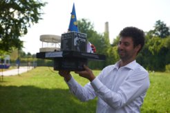 Marcel Duda eying the doctoral hat that his lab colleagues made for him.