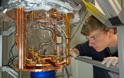Andreas Gritsch am Kryostat, in dem das mit Erbium-Atomen dotierte Silizium bis auf wenige Grad über dem absoluten Nullpunkt heruntergekühlt wird.