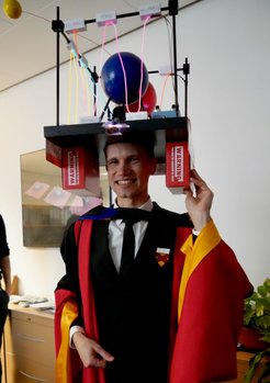 Vitaly Wirthl nach der erfolgreichen Verteidigung seiner Disseration. Der Doktorhut wird traditionsgemäß von den Laborkolleg:innen des Doktoranden gebastelt.